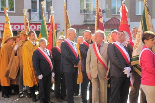 Uroczysty przemarsz pszczelarzy z pocztami sztandarowymi i szarfami na Dniach Pszczelarzy.