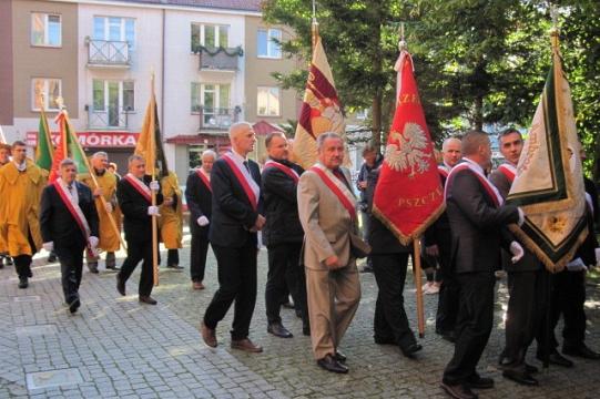Pochód pszczelarzy z chorągwiami na ulicach Koszalina podczas Dni Pszczelarzy.
