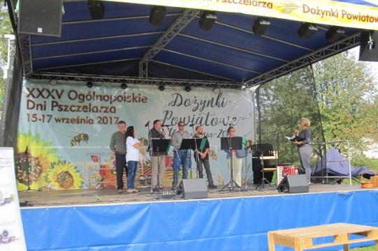 Grupa ludzi występuje na scenie podczas Ogólnopolskich Dni Pszczelarzy.