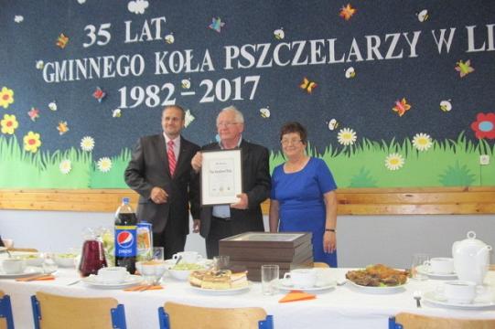 Trzy osoby z dyplomem na uroczystości 35-lecia Koła Pszczelarzy w Lini.
