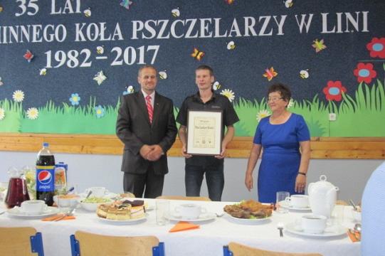 Uroczystość wręczenia wyróżnienia z okazji 35-lecia Koła Pszczelarzy w Lini, przy stole.