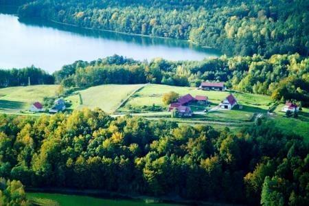 Malowniczy widok lotniczy na jezioro, lasy i zabudowania Gminy Linia.