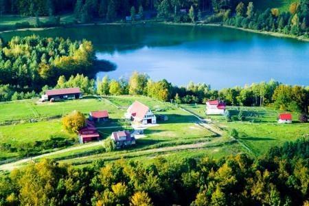 Malowniczy widok lotniczy Gminy Linia z jeziorem, zielenią i rozproszonymi domami.