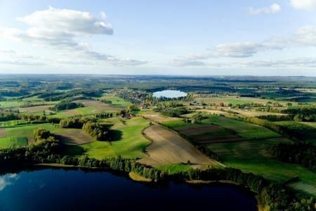 Malownicza panorama Gminy Linia z jeziorami i zielonymi terenami pod błękitnym niebem.