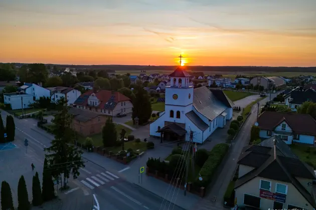 Zachód słońca nad kościołem i zabudowaniami miejscowości Linia