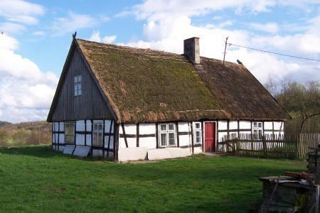 Zielony Dworek w Strzepczu, tradycyjny dom szachulcowy z czerwoną drzwiami.
