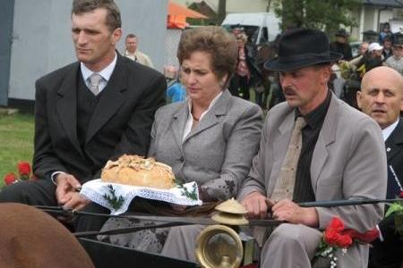 Uczestnicy dożynek prezentują bochen chleba podczas uroczystości.
