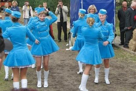 Tancerki w niebieskich strojach z białymi butami podczas dożynek.