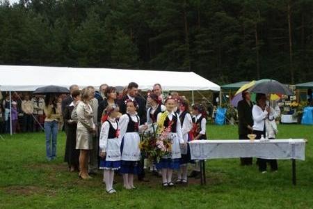 Osoby w strojach ludowych na Dożynkach Gminnych 2008, obok białego namiotu.