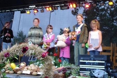 Uczestnicy Dożynek Gminnych 2008 z wieńcami i plonami na scenie.