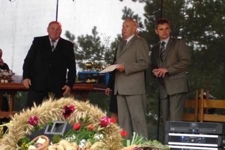 Mężczyźni na scenie z wieńcem dożynkowym na Dożynkach Gminnych 2008.