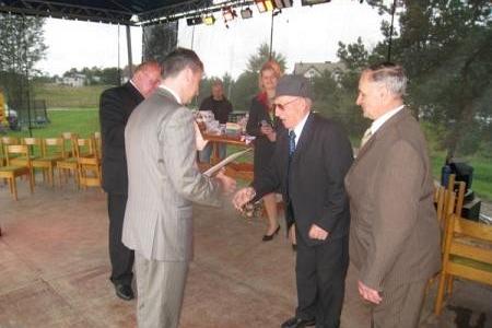 Mężczyźni w garniturach witają się na Dożynkach Gminnych 2008.