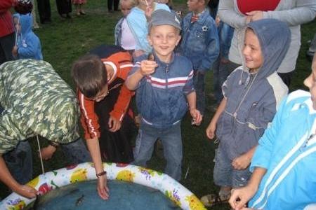 Dzieci przy zabawie z łowieniem w basenie na festynie dożynkowym.