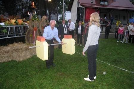 Dożynki Gminne 2008: mężczyzna z chlebem ceremonialnym i kobieta na świeżym powietrzu.