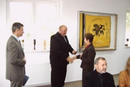 Wręczenie stypendiów: mężczyzna gratuluje studentce, reszta osób patrzy.