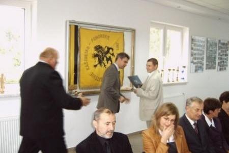 Wręczenie stypendium studentowi podczas uroczystości w obecności publiczności.