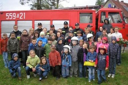 Dzieci i dorośli ze Strzepcza na pokazie OSP przed wozem strażackim.