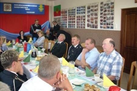 Uczestnicy Zjazdu OSP 2011 siedzą przy stole w sali.