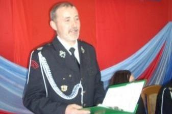 Członek OSP w galowym mundurze przemawia na tle dekoracji podczas Zjazdu OSP 2011.
