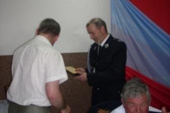 Na Zjeździe OSP 2011 dwaj mężczyźni rozmawiają, a trzeci w mundurze obserwuje.