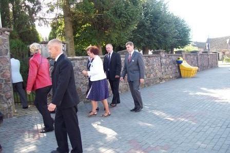 Uczestnicy uroczystości związanej ze sztandarem OSP Lewino stoją na zewnątrz.