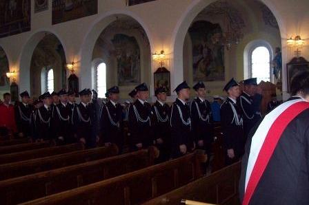 Zastępy OSP Lewino w galowych mundurach na uroczystości sztandarowej w kościele.