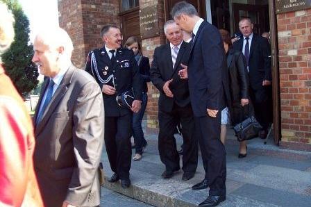 Delegacja mężczyzn w strojach galowych i mundurach na uroczystości OSP Lewino.