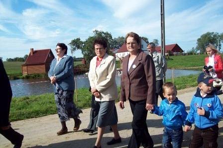 Mieszkańcy Lewina, dorośli i dzieci, uczestniczą w pochodzie podczas wydarzenia OSP.