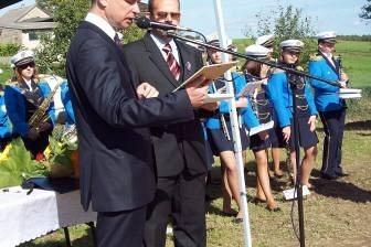 Mężczyźni przemawiają na uroczystości OSP Lewino pod namiotem.