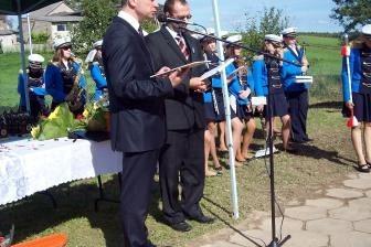 Mężczyzna w garniturze wygłasza przemówienie pod namiotem na uroczystości OSP Lewino.