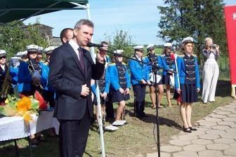 Mężczyzna w garniturze przemawia do strażaków OSP Lewino podczas uroczystości.