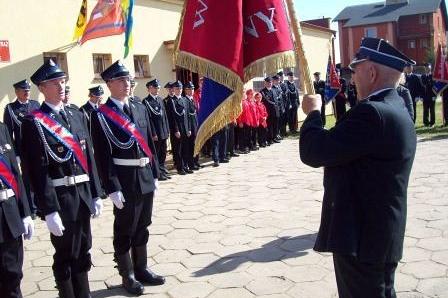 Członkowie OSP Lewino w mundurach podczas uroczystości ze sztandarem.
