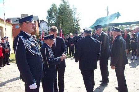 Strażacy z OSP Lewino w mundurach podczas powitania na uroczystości.