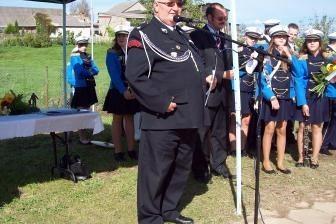 Mężczyzna w galowym mundurze OSP Lewino przemawia do zgromadzonych.
