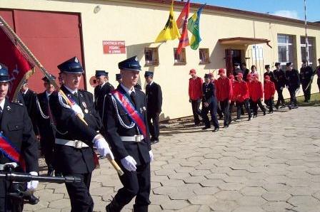 Strażacy OSP Lewino w mundurach podczas uroczystości przed remizą.