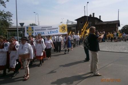 Pochód uczestników XVI Zjazdu Kaszubów w Pruszczu Gdańskim z flagami na ulicy.