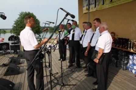 Męski chór z muzykiem występuje na scenie plenerowej festiwalu.