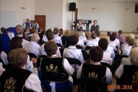 Widownia i chórzyści na scenie podczas występu w Domu Kultury.