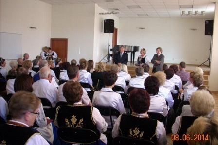 Uczestnicy spotkania chóralnego siedzą w sali Domu Kultury