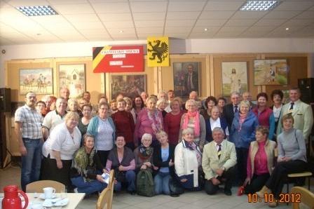 Duża grupa chórzystów pozuje do zdjęcia w sali GDK Linia.