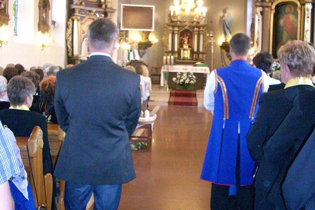 Uczestnicy Zjazdu Chórów Kaszubskich w kościele idący nawą główną ku ołtarzowi.
