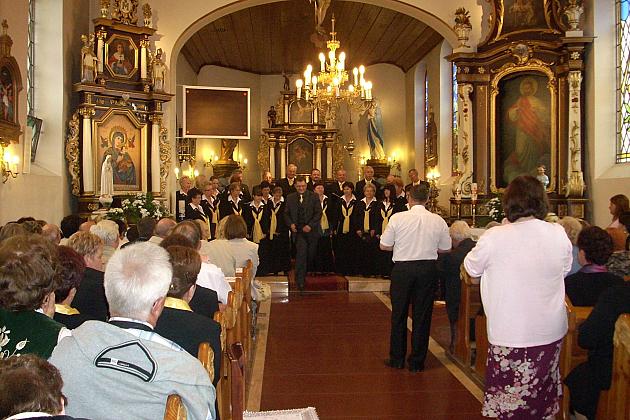 W ozdobnym kościele Chór Pięciolinia śpiewa dla publiczności zgromadzonej w ławkach.
