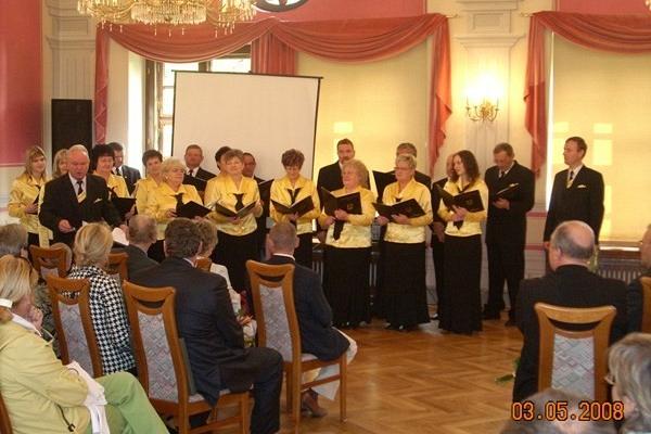 Występ chóru Pięciolinia w sali z publicznością.
