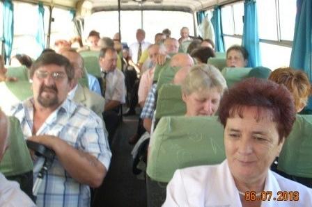 Ludzie jadą autobusem na Zjazd Kaszubów, widać twarze uczestników, wnętrze pojazdu.
