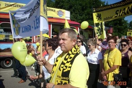 Zgromadzenie ludzi w żółto-czarnych barwach z flagami na Zjeździe Kaszubów we Władysławowie.