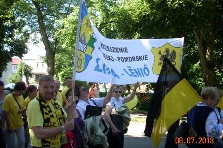 Uczestnicy XV Zjazdu Kaszubów maszerują z flagami i transparentem we Władysławowie.