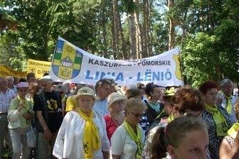 Tłum uczestników XV Zjazdu Kaszubów w plenerze, pod transparentem.
