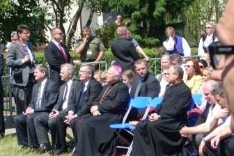 Ludzie w ciemnych strojach siedzą na zjeździe Kaszubów we Władysławowie.