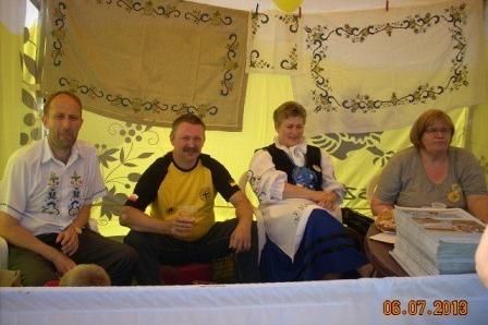Cztery osoby siedzą przy stole podczas Zjazdu Kaszubów we Władysławowie pod namiotem.