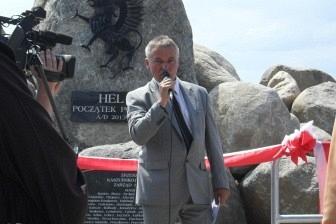 Ludzie podczas uroczystości odsłonięcia Kopca Kaszubów, jeden mówi do mikrofonu.